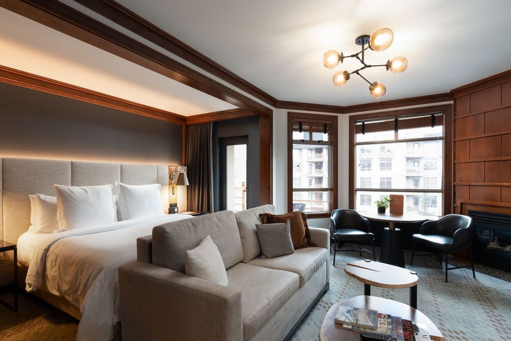 Boutique hotel suite with wood panelling, fireplace and warm lighting